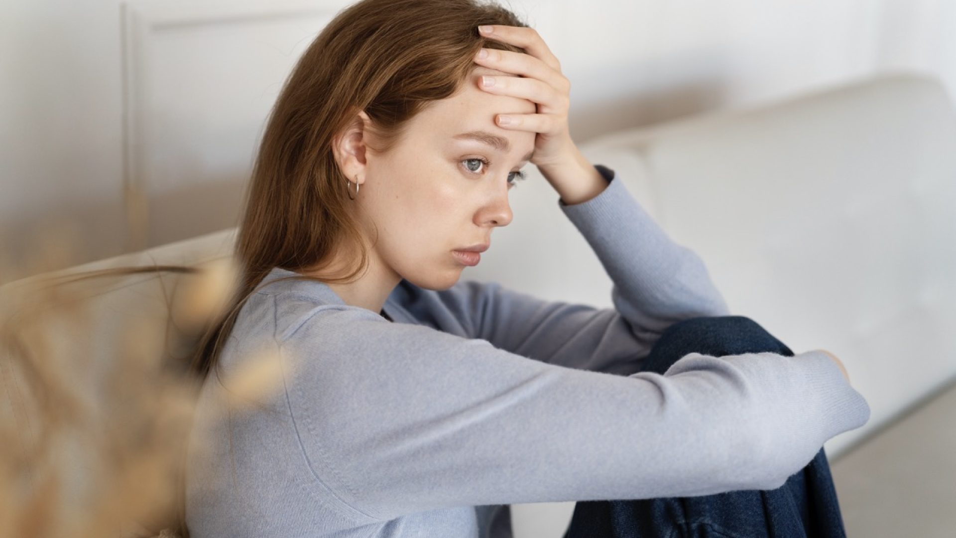 anxious-woman-sitting-couch-side-view - dimensioni grandi