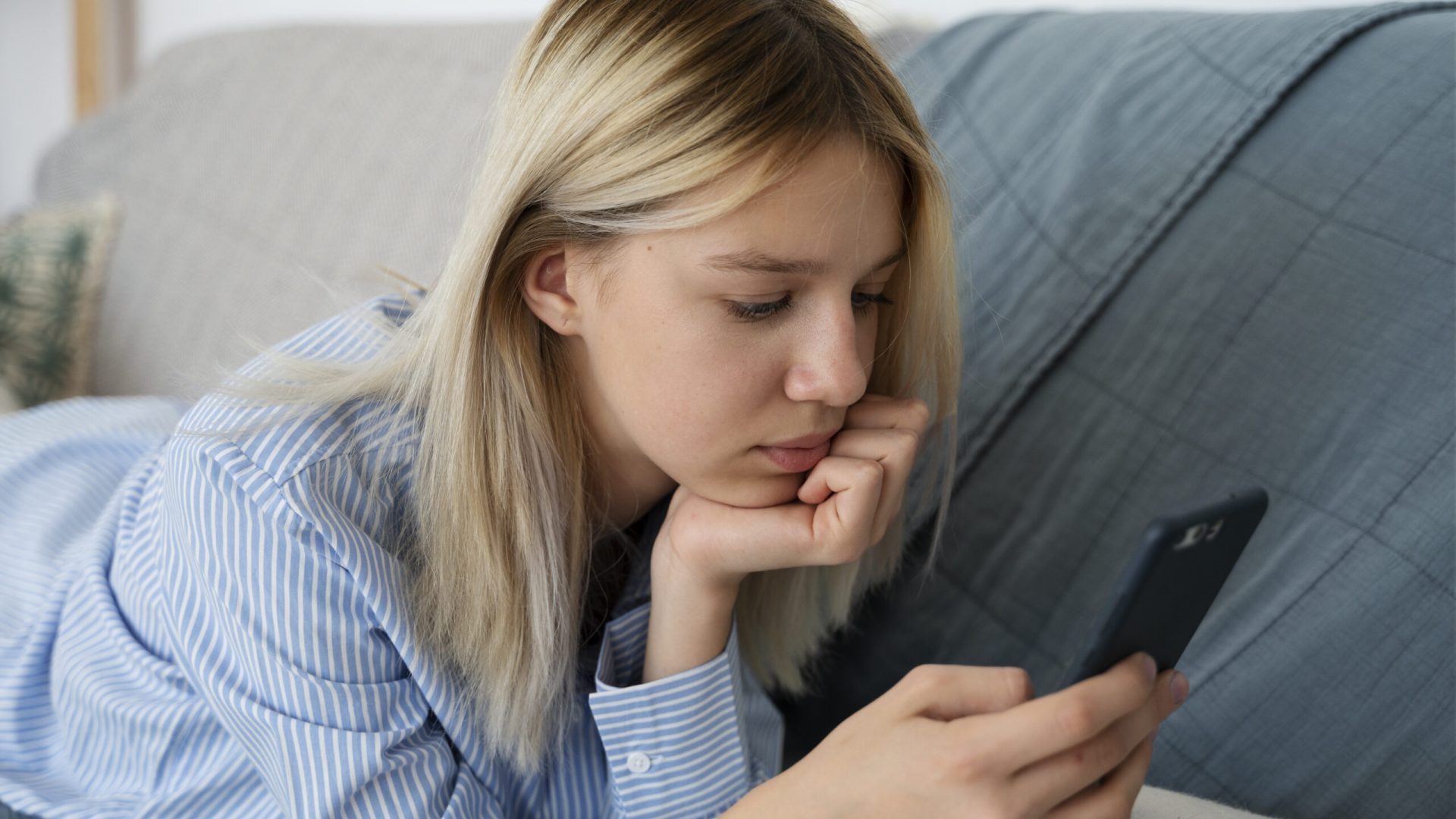 girl-couch-with-smartphone-side-view