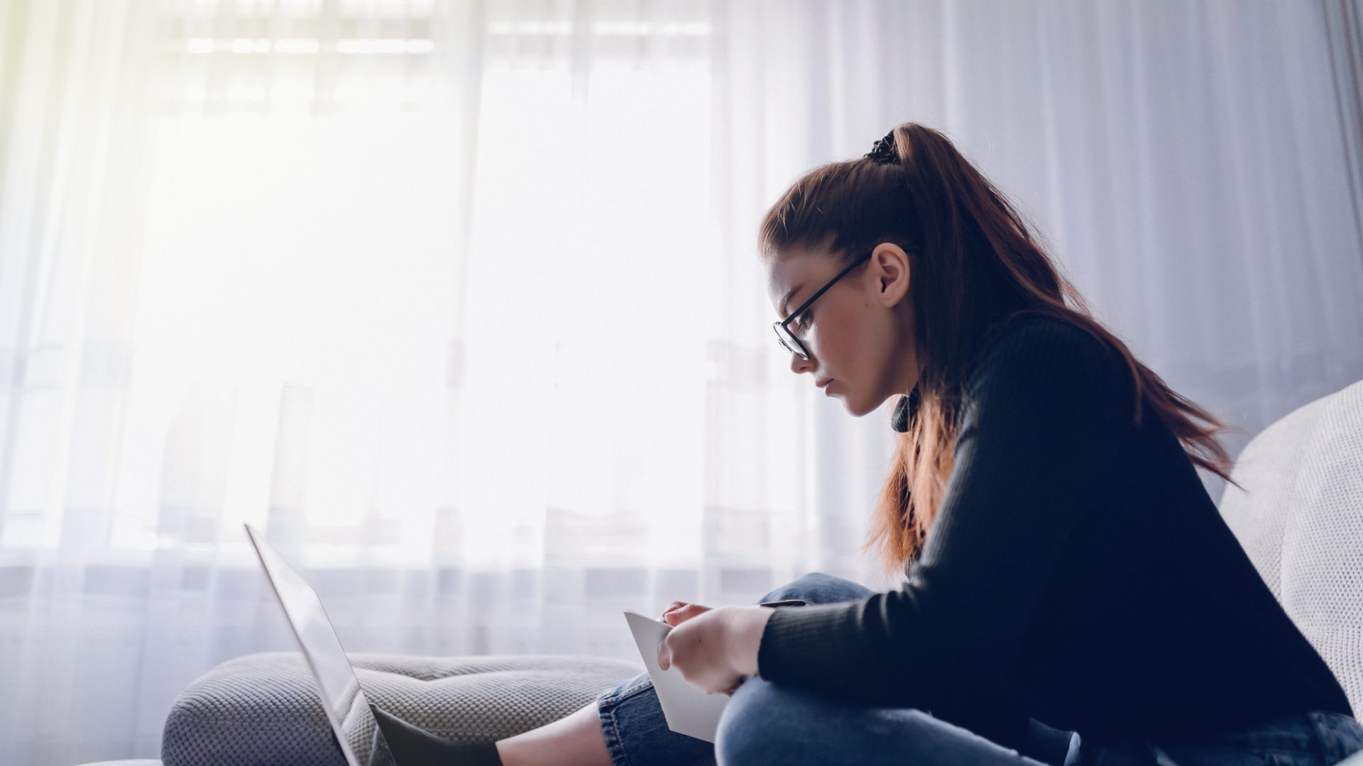 young-attractive-girl-home-working-with-laptop-couch-comfort-coziness-while-home-home-office-work-from-home-remote-online-employment